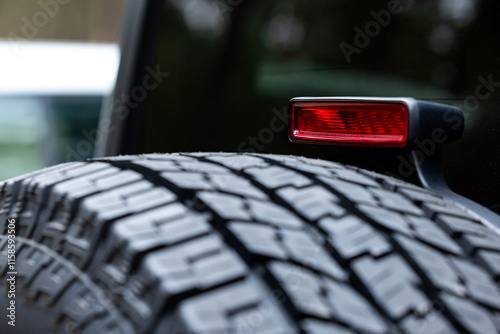 Obraz na płótnie Deep tread of a new off road tire mounted on the rear door of an off-road vehicle. The photo was taken during the day. w salonie