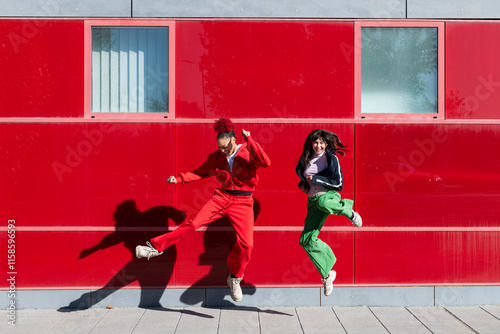 Friends jumping near red wall photo