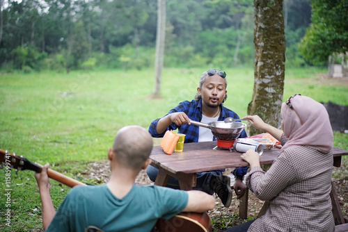 Indonesian men and women in hijab relaxing in front of a forest cabin and frying frozen food, staying in a forest cabin, travel concept. photo