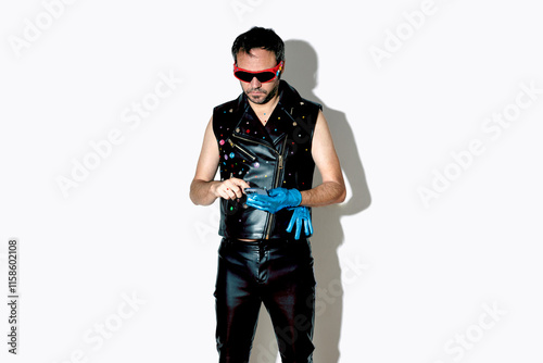 Man with rock style jacket and gloves using smart phone against white background photo