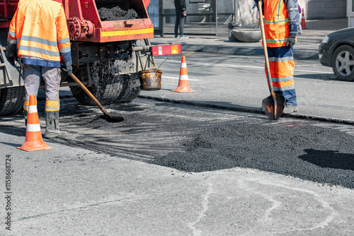 Obraz na płótnie Road workers repair asphalt surface during bright day in urban setting w salonie