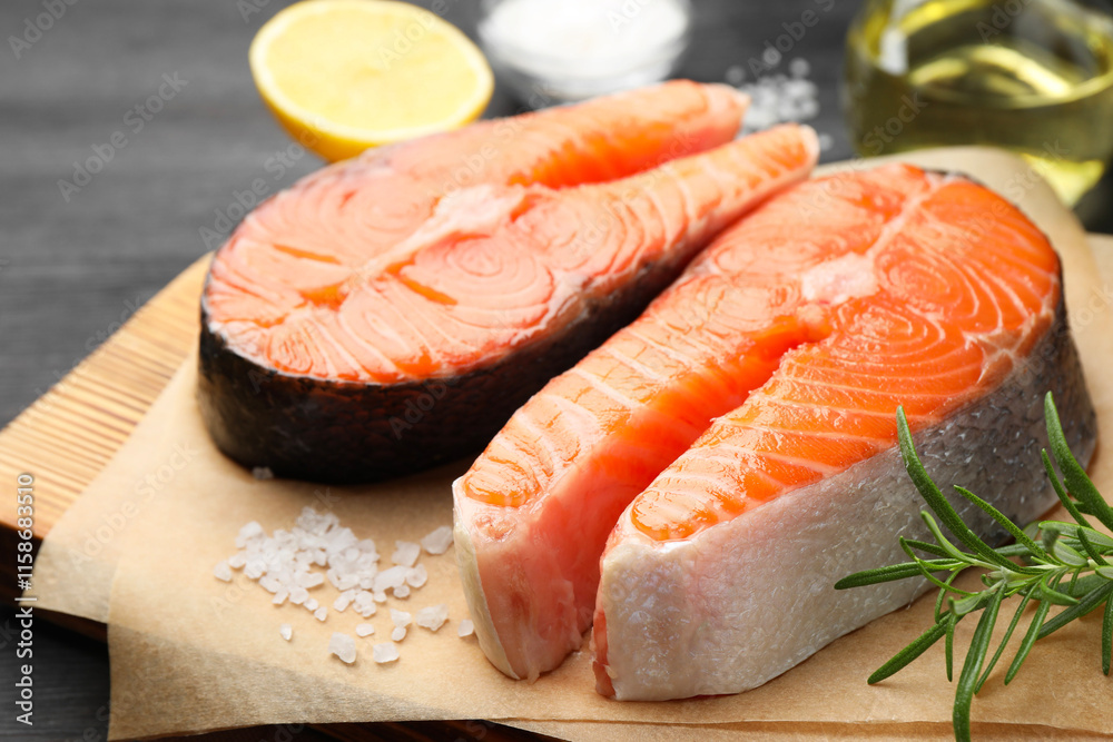 Fresh raw salmon steaks and spices on black table, closeup Fresh raw salmon steaks and spices on black table, closeup