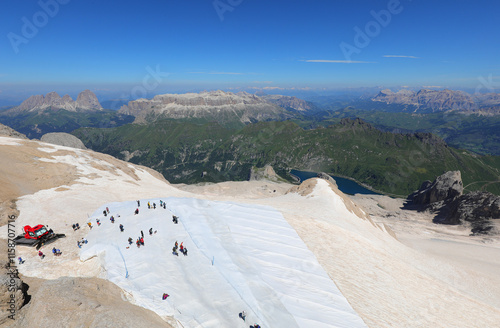 marmolada glacier covered with a protective sheet with people walking on it and a snowcat in summer photo