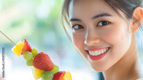 Woman smiling while holding a fruit skewer