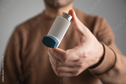 Caucasian man with a asthma inhaler. Concept of treatment of bronchial asthma