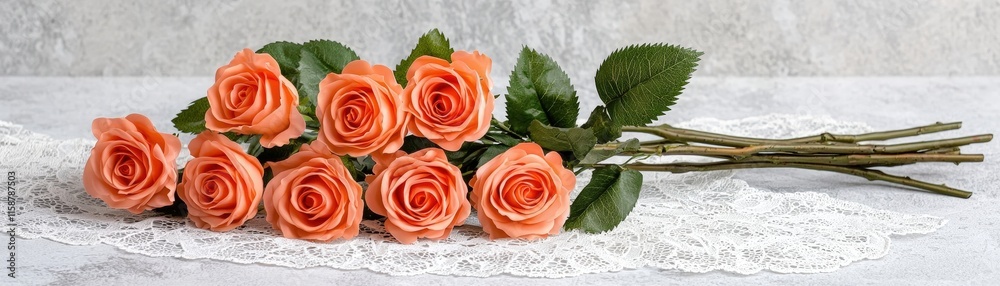 Fototapeta premium Elegant Arrangement of Soft Orange Roses on Lace Background for Wedding or Event Decorations