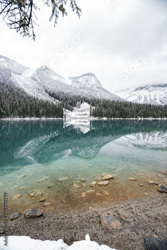 Maligne Lake in Alberta, Canada, in winter with snow covered mountains and turquoise colored water and a cloudy sky. Canada travel destination. Background photo