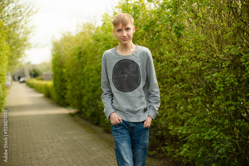 Smiling Blond Man in Blue Jeans and Gray Sweater Walking in Park Happy and Relaxed
