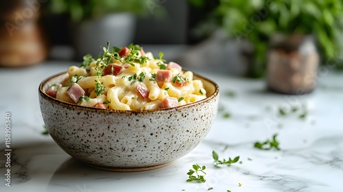 Creamy macaroni pasta salad served in ceramic bowl features ham cubes and fresh herbs, styled professionally on white marble countertop with soft lighting and shallow depth creating food presentation