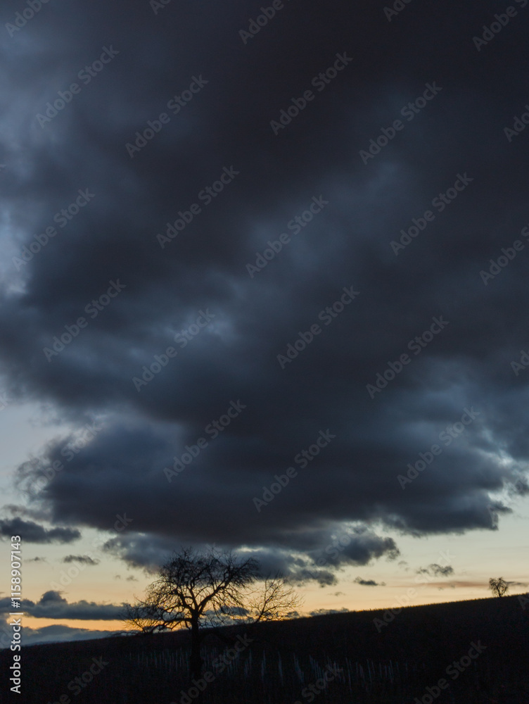 Paysage crépusculaire : un ciel lourd au coucher du soleil Paysage crépusculaire : un ciel lourd au coucher du soleil