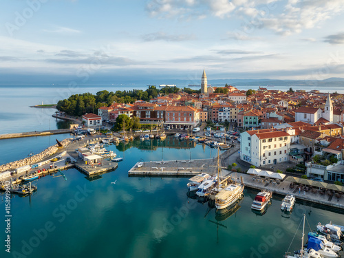 Aerial panoramic view of picturesque Izola town with the old town and buildings with red roofs, the main promenade, the marina with boats on Adriatic sea coast, Slovenia.