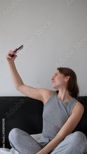 Woman Posing for Selfie on Phone. Relaxing in Bed, Taking Selfie