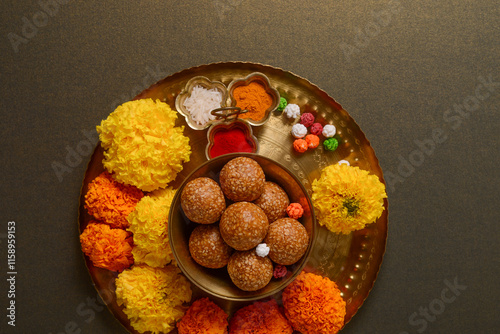 A puja thali for Makar Sankranti festival consists of Tilgul, flowers and haldi kumkum. Hindu religious objects and food.