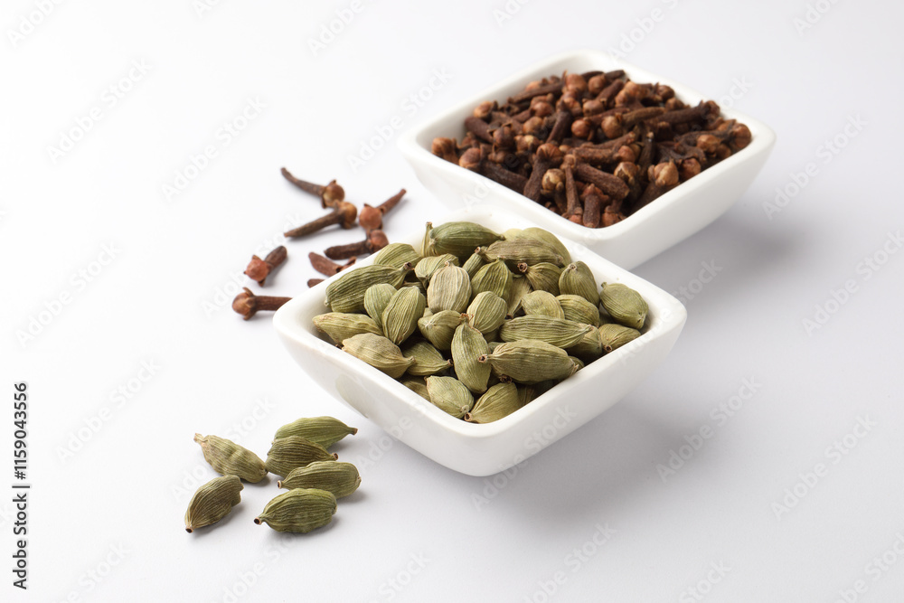 Indian spices Cardamom and Cloves in ceramic bowls Indian spices Cardamom and Cloves in ceramic bowls