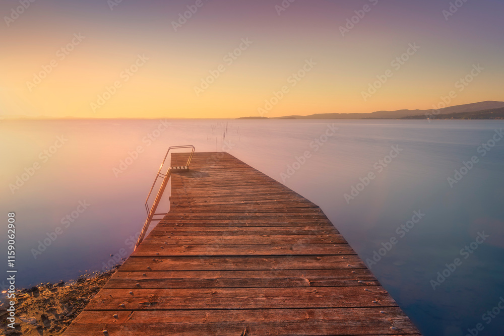 Obraz premium Wooden pier on Lake Trasimeno. Long exposure photography. Magione, Umbria, Italy