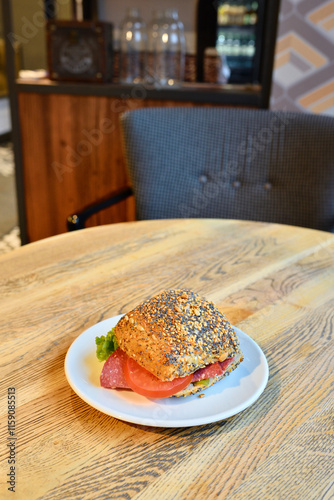 Salami sandwich on a woodem table in a cozy location offering bread and baked food. photo