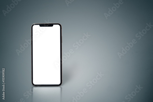 A white phone is sitting on a grey surface. The screen is black and the phone is turned off