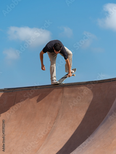 young skater wearing black tshirt skating in Arinaga skate park in a sunny day