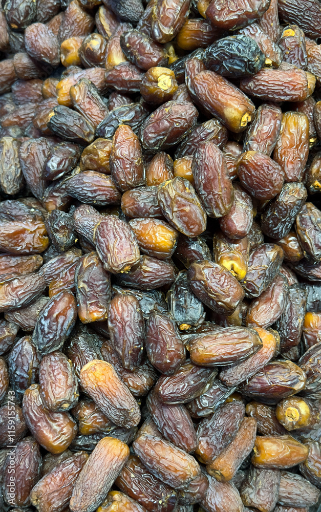 A close-up photograph of a large pile of dried dates and dates fruit A close-up photograph of a large pile of dried dates and dates fruit