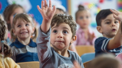 Active classroom with engaged children and a teacher. Students sitting on benches, one boy raising hand with curiosity. Nurturing, interactive learning environment with whiteboards.