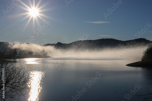 Blick auf den Diemelstausee in Hessen. Wir schauen gegen die Sonne, Nebel liegt über dem Wasser. Mysteriös, geheimnisvoll, stimmungsvoll, kalt