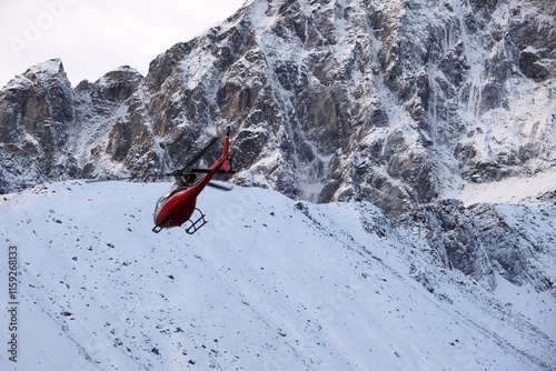 Rescue helicopter in action in Himalayas. Gokyo, Sagarmatha National Park, Khumbu valley, Nepal photo