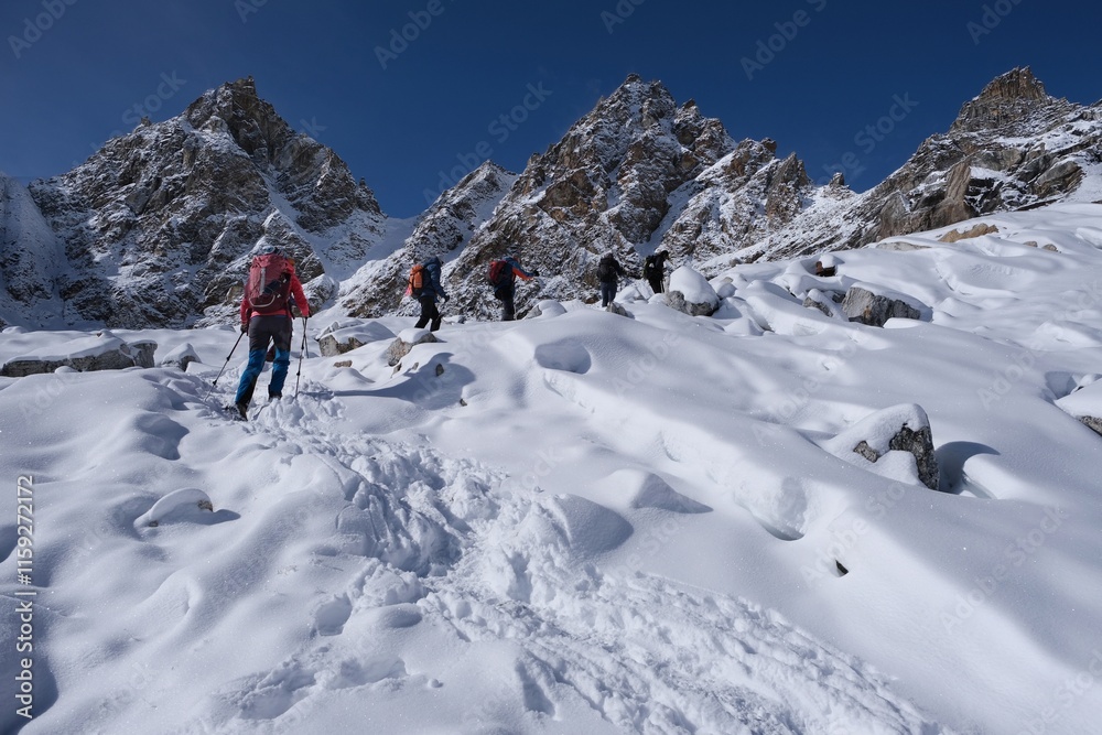Winter mountain panorama with climbing trekkers during route to Renjo La Pass. Sagarmatha National Park, Himalayas, Nepal Winter mountain panorama with climbing trekkers during route to Renjo La Pass. Sagarmatha National Park, Himalayas, Nepal