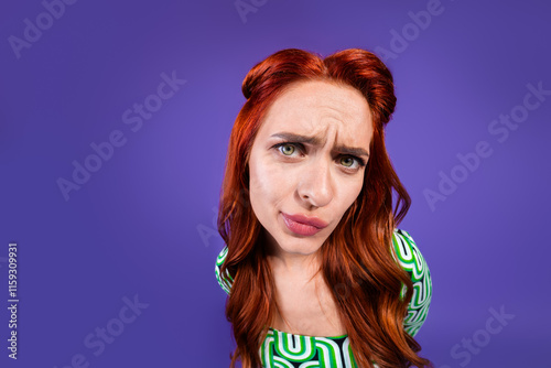 Stylish Redhaired Woman Expressing Curiosity with a Vibrant Violet Background photo