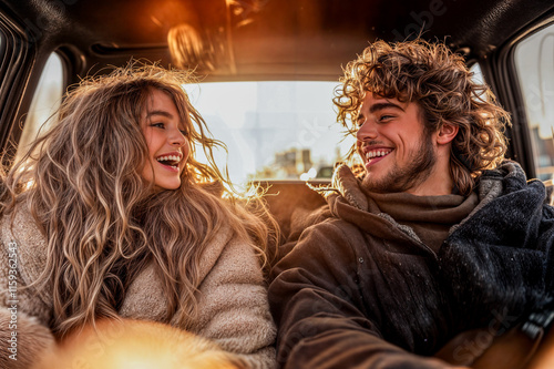 Jeune couple rigolant assis à l'arrière d'une voiture photo