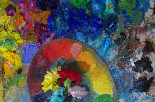 Art palette and fresh flowers on an abstract art background. photo