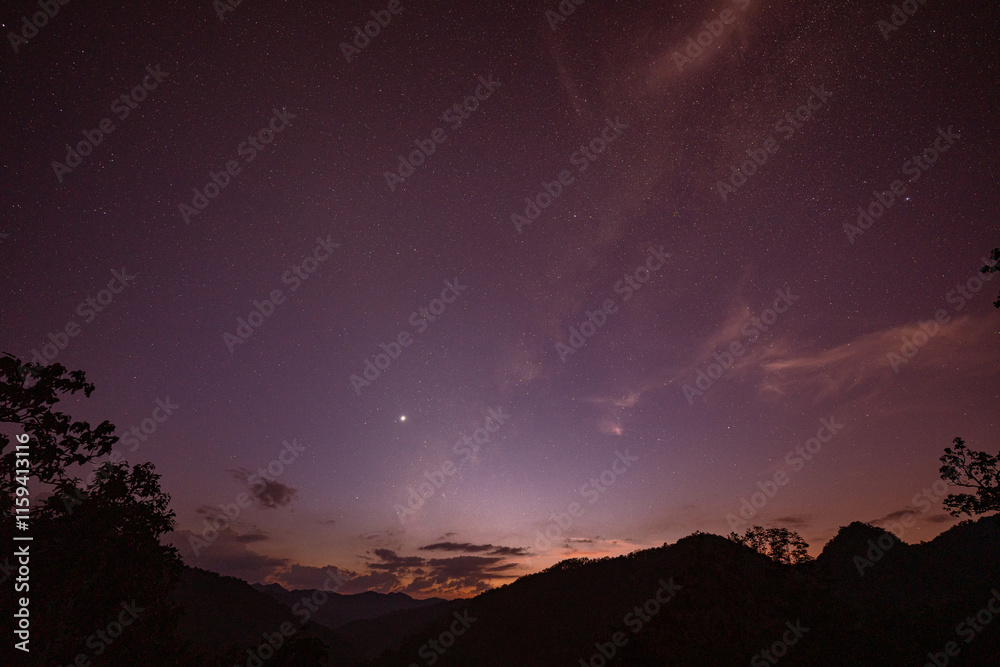 Milky Way above mountains at night in autumn. Landscape with mountain valley, low clouds, purple starry sky with milky way. The Milky Way shines on a cold night in the north of Thailand Milky Way above mountains at night in autumn. Landscape with mountain valley, low clouds, purple starry sky with milky way. The Milky Way shines on a cold night in the north of Thailand