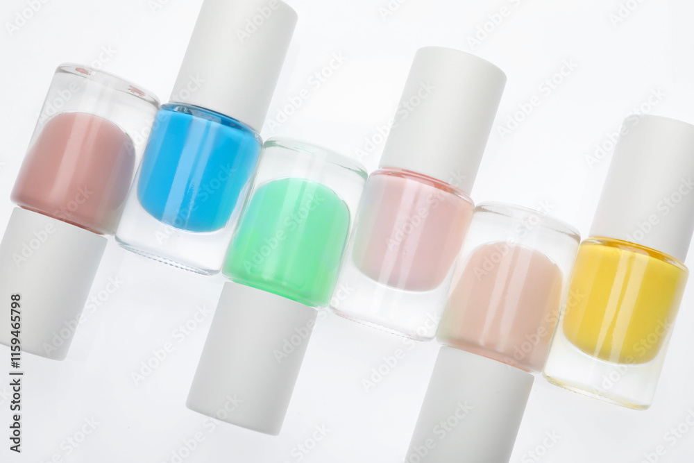 Nail polishes in bottles on white background, top view Nail polishes in bottles on white background, top view