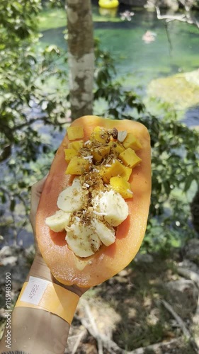 Heart Cenote in Mexico with crystal-clear waters and visible stones. A person happily jumping into the water. Warm, blue-green waters perfect for a family vacation in Yucatán, Mexico.