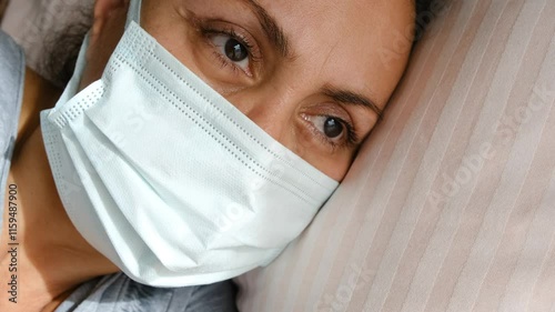 sick woman in mask lying in bed