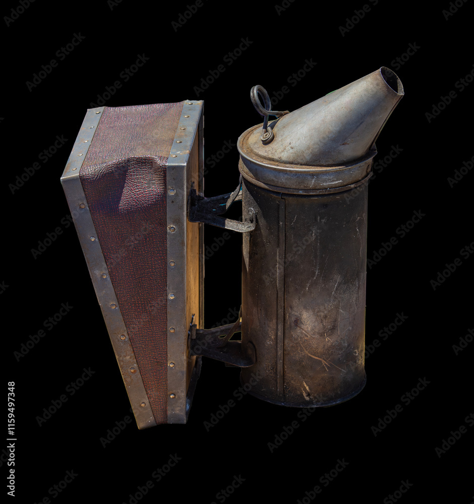 This vintage beekeeping smoker with attached bellows is used for calming bees during hive inspections, highlighting traditional beekeeping practices.