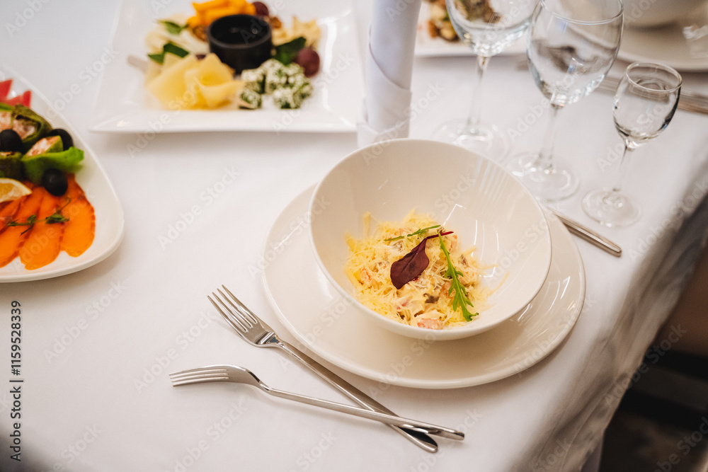 There is a table that is adorned with various plates filled with an assortment of delicious food items and utensils carefully arranged on it, ready for a delightful dining experience