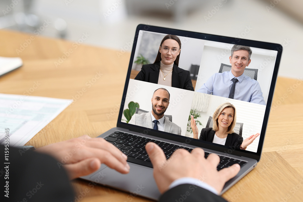 Fototapeta premium Business meeting. Man using laptop during online video chat at table, closeup