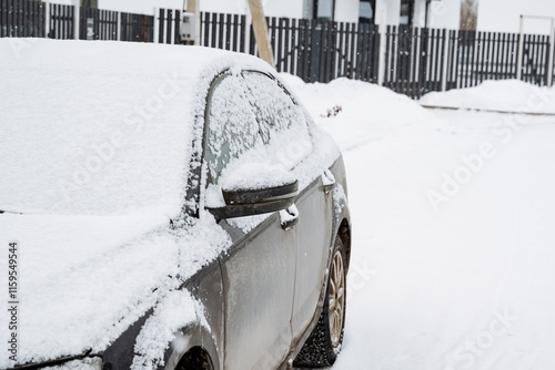 A small, compact car is completely covered in a thick layer of fresh snow, resting quietly by a wintry road, as it endures the harsh and tough winter conditions and the biting cold air around it photo