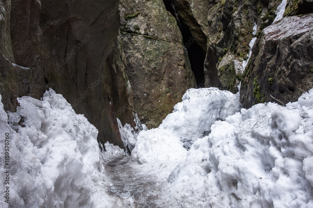 Narrow pass in Bledne Skaly rocks, Poland with icy snow danger path