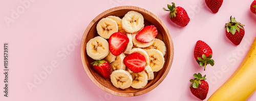 Obraz na płótnie Fresh fruit in a wooden bowl, sliced strawberries and bananas, healthy lifestyle background. w salonie