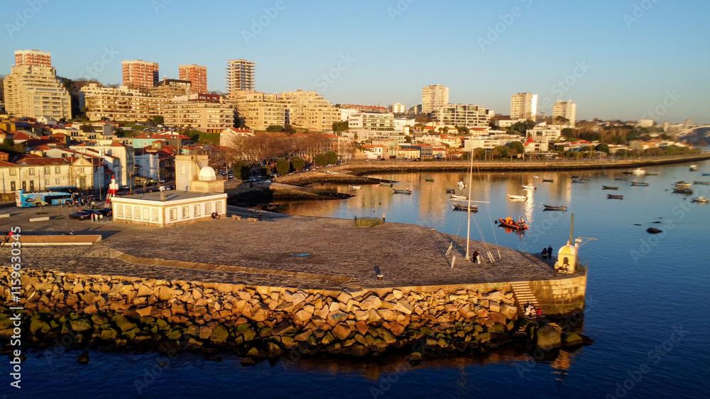 Fototapeta premium Vista capturando a deslumbrante paisagem do Porto e de Matosinhos, onde o Rio Douro encontra o Oceano Atlântico. A cena apresenta as areias douradas da praia de Matosinhos, 