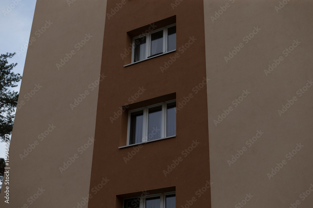 This is an exterior view of a modern residential building that prominently features multiple windows This is an exterior view of a modern residential building that prominently features multiple windows