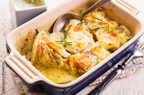 Traditional Italian chicory gratinated with buffalo mozzorella and herbs served as closeup in a classical backing form photo