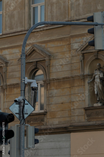 Vertical traffic light is displaying a green signal on the street situated near a prominent historical building in the city