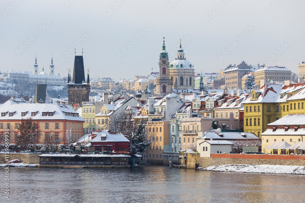 Fototapeta premium Snowy Prague Lesser Town with St. Nicholas' Cathedral in the sunny Day