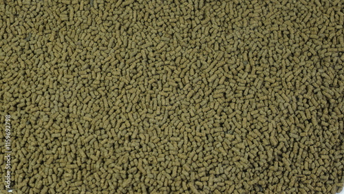 Shrimp feed in pellet form, animal feed used in farms in the form of long, dark brown pellets.