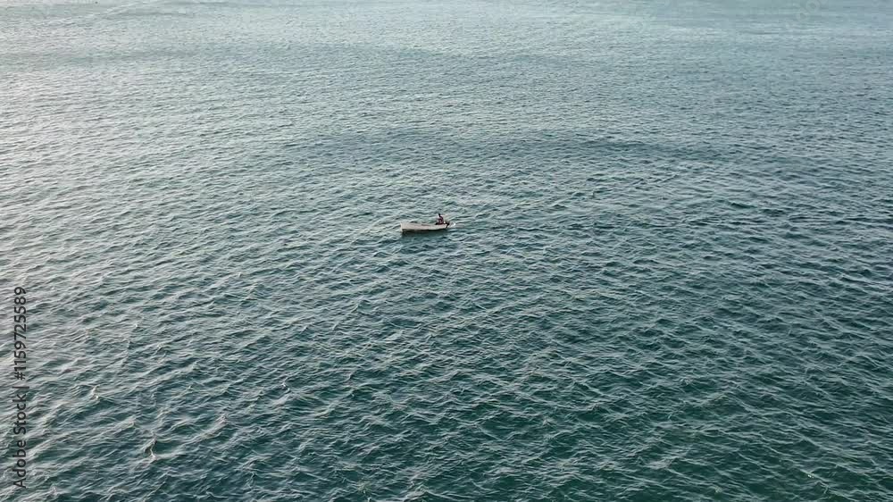 A small boat surrounded by the vast blue ocean, with the sky melting into the horizon.
A small boat surrounded by the vast blue ocean, with the sky melting into the horizon.