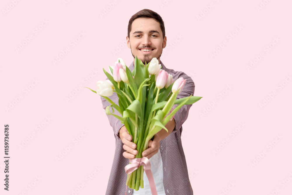 Happy young man with bouquet of beautiful tulips on pink background. International Women's Day Happy young man with bouquet of beautiful tulips on pink background. International Women's Day