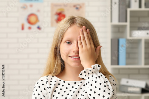 Teenage girl checking her eyesight at ophthalmologist's office, closeup. Chil...