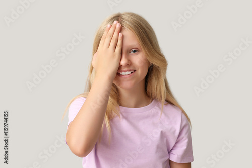 Teenage girl checking her eyesight on light background. Children's Eye Health...